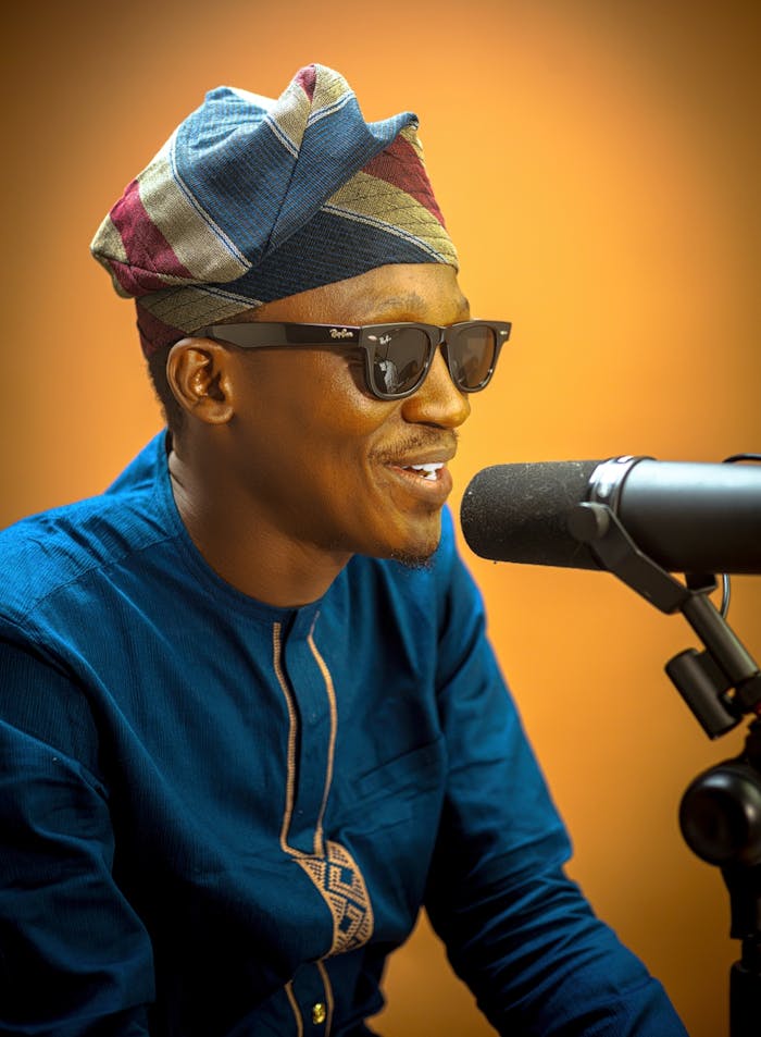 Smiling Man in Traditional Attire with Microphone